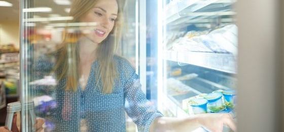 Woman reaching into refrigerator